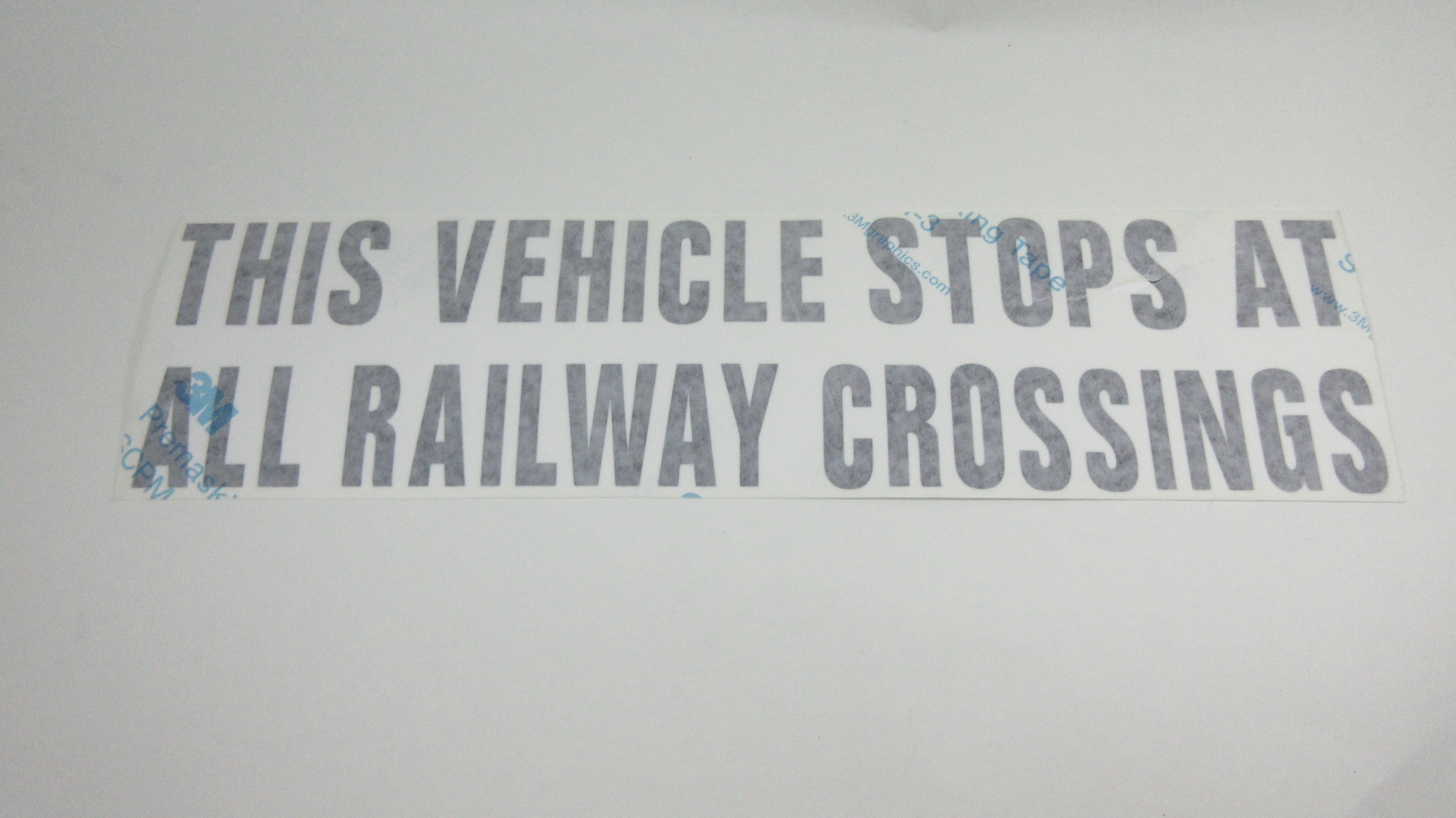 DECAL,STOPS AT RAIL,BLK TRANSF