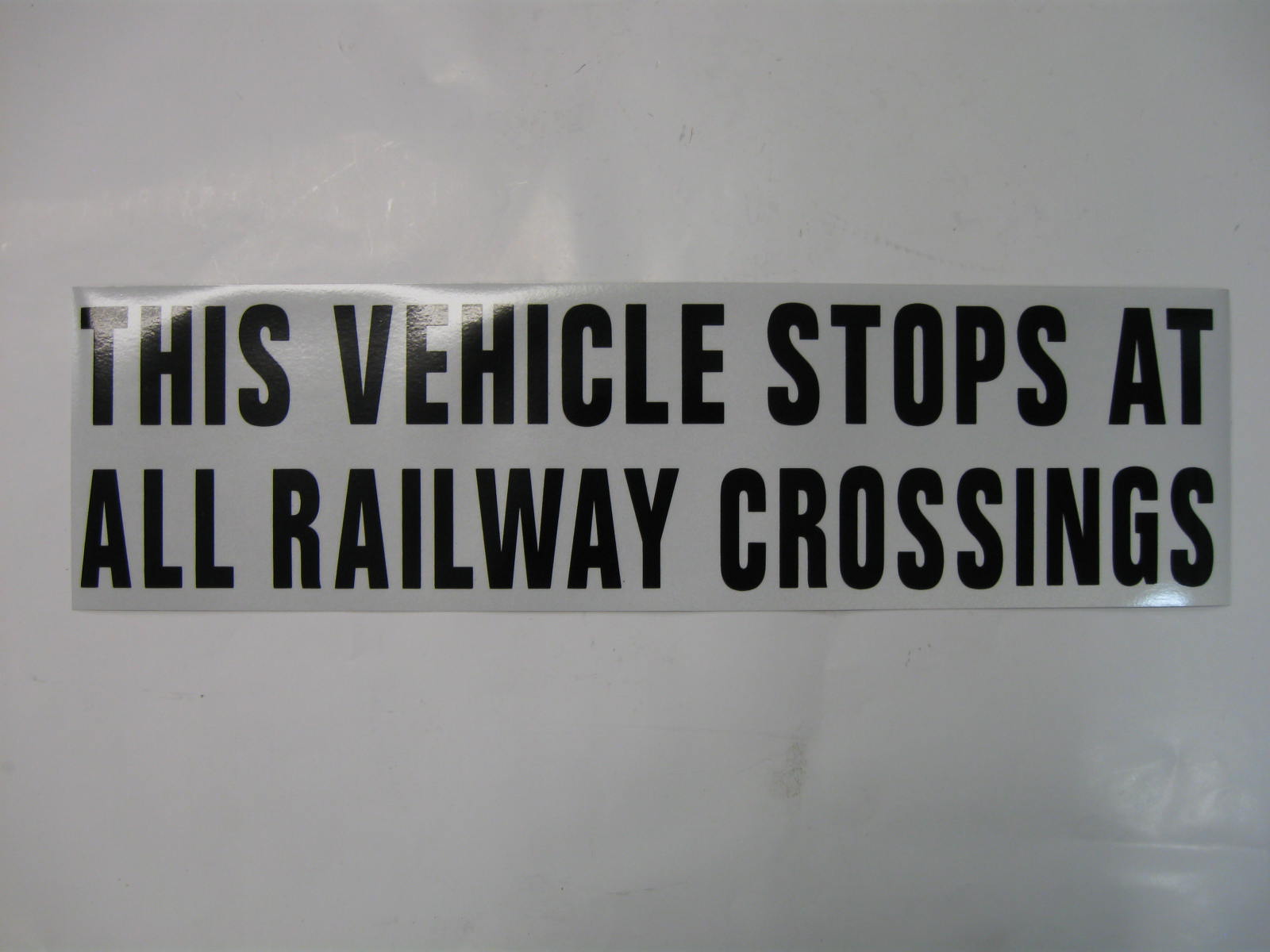 DECAL,STOPS AT RAIL,BLK ON WHT